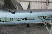 Flügelvorderkante mit der Mündung einer Kanone, dem Glasfenster der BSK 16 und der Knickstrebe des Fahrgestells
