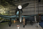 Flugzeugführerfigur als Größenvergleich neben der Luftschraube mit weißem Spinner 

