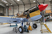 Aufgebockte Curtiss P-40 F 'Kittyhawk' X-17 bei Wartungsarbeiten im Hangar des IWM Duxford 
